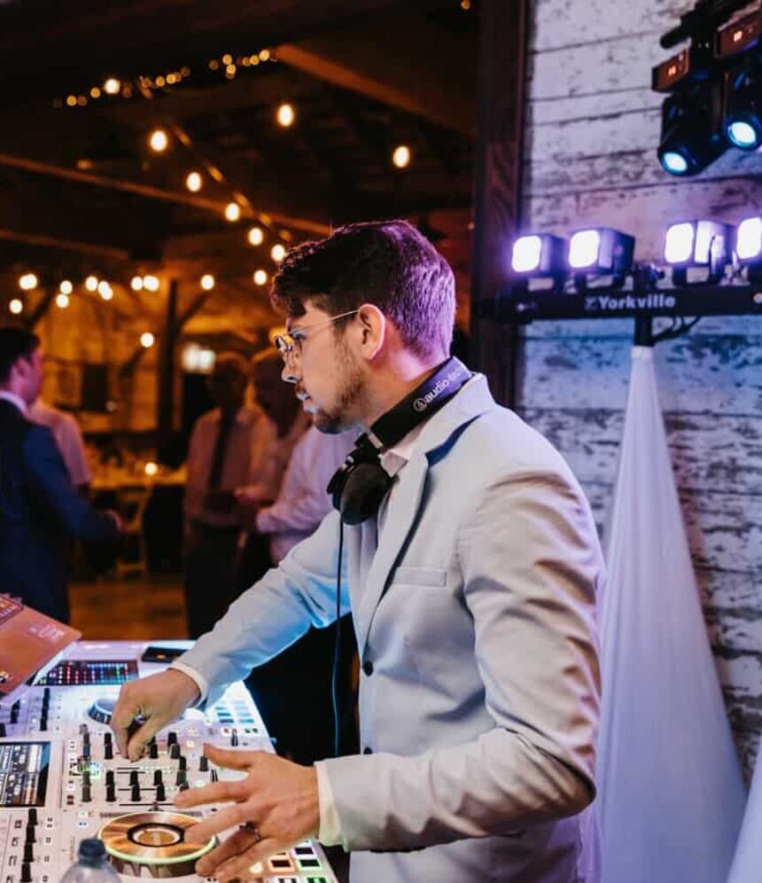Lucas Pardy of Pardy DJ Co. live-mixing at a string-lit wedding reception