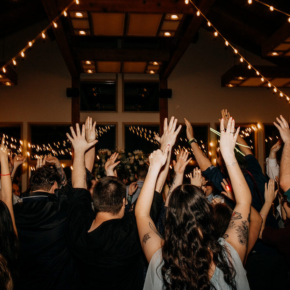 A packed wedding dance floor, every hand in the air, at Whonnock Lake hall in Maple Ridge