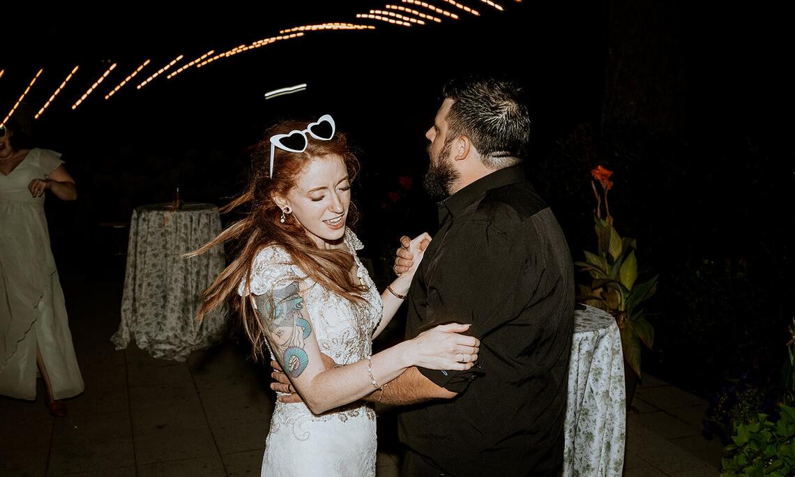 A couple slow dancing under string lights as their reception winds down at Sandpiper Resort, Harrison Mills