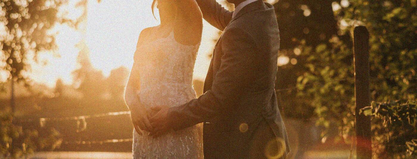 A couple embracing at sunset after their wedding ceremony